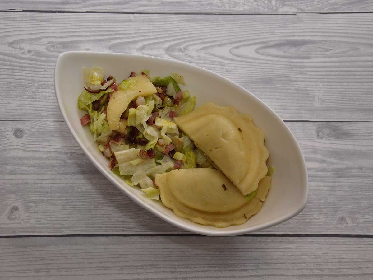 Appel spek salade met ravioli in een wit schaaltje.