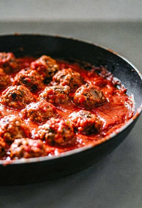 Een koekenpan vol met Italiaanse gehaktballetjes.