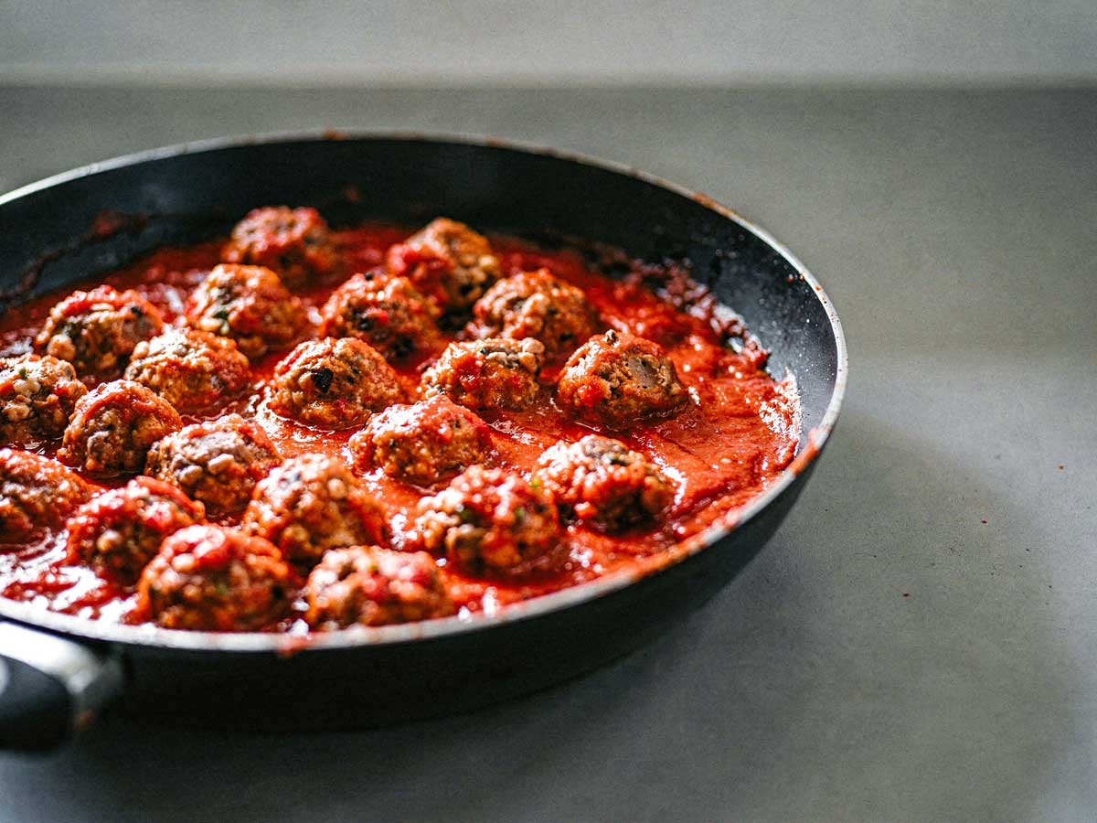 Een koekenpan vol met Italiaanse gehaktballetjes.