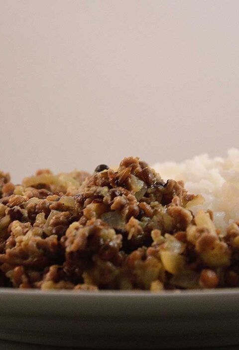 Linzen Bloemkool Curry met rijst, op een wit bord.