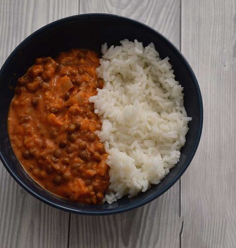 Linzencurry in een blauw schaaltje met witte rijst.
