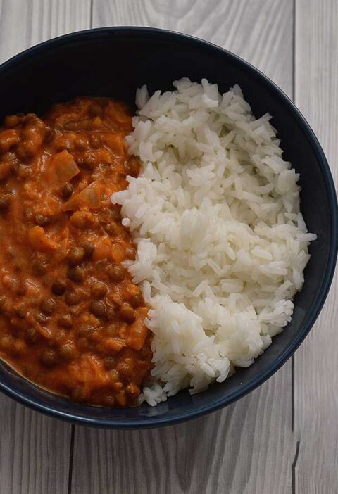 Linzencurry in een blauw schaaltje met witte rijst.