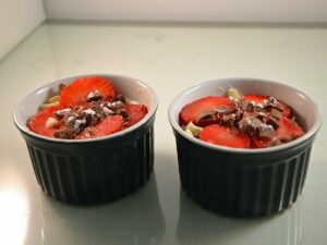 Mascarponekwark met aardbeien in twee kleine schaaltjes.