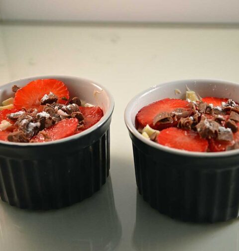 Mascarponekwark met aardbeien in twee kleine schaaltjes.