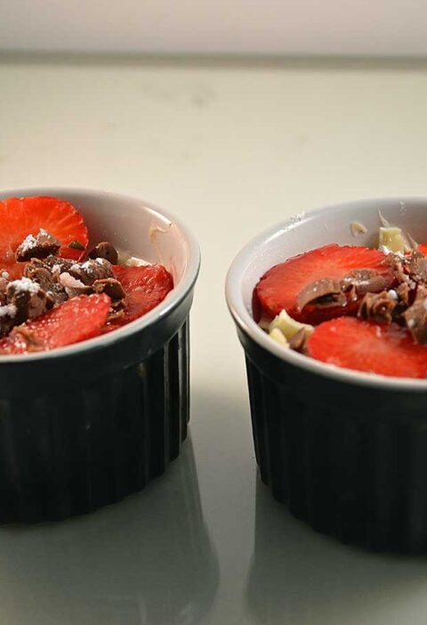 Mascarponekwark met aardbeien in twee kleine schaaltjes.