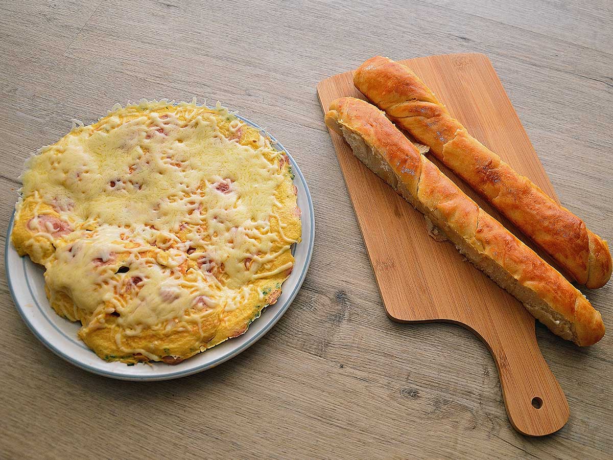 Omelet met worst en kaas op een bruine ondergrond.