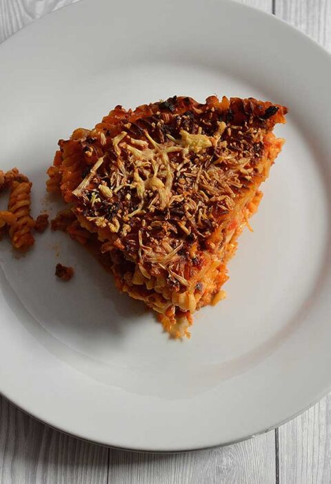 Een stuk pastataart Bolognese op een wit bord.
