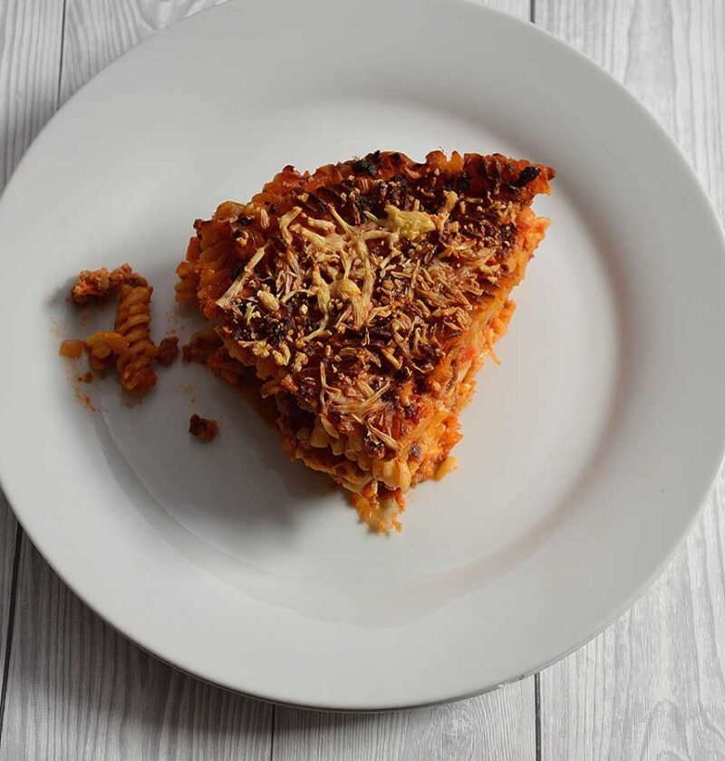 Een stuk pastataart Bolognese op een wit bord.