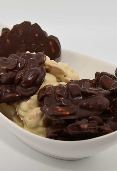 Een schaaltje met zelfgemaakte pindarotsjes, witte en pure chocolade.