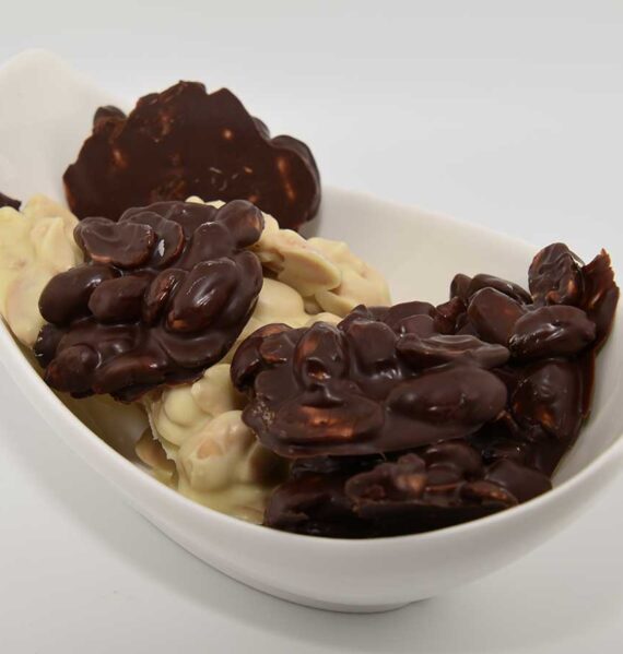 Een schaaltje met zelfgemaakte pindarotsjes, witte en pure chocolade.
