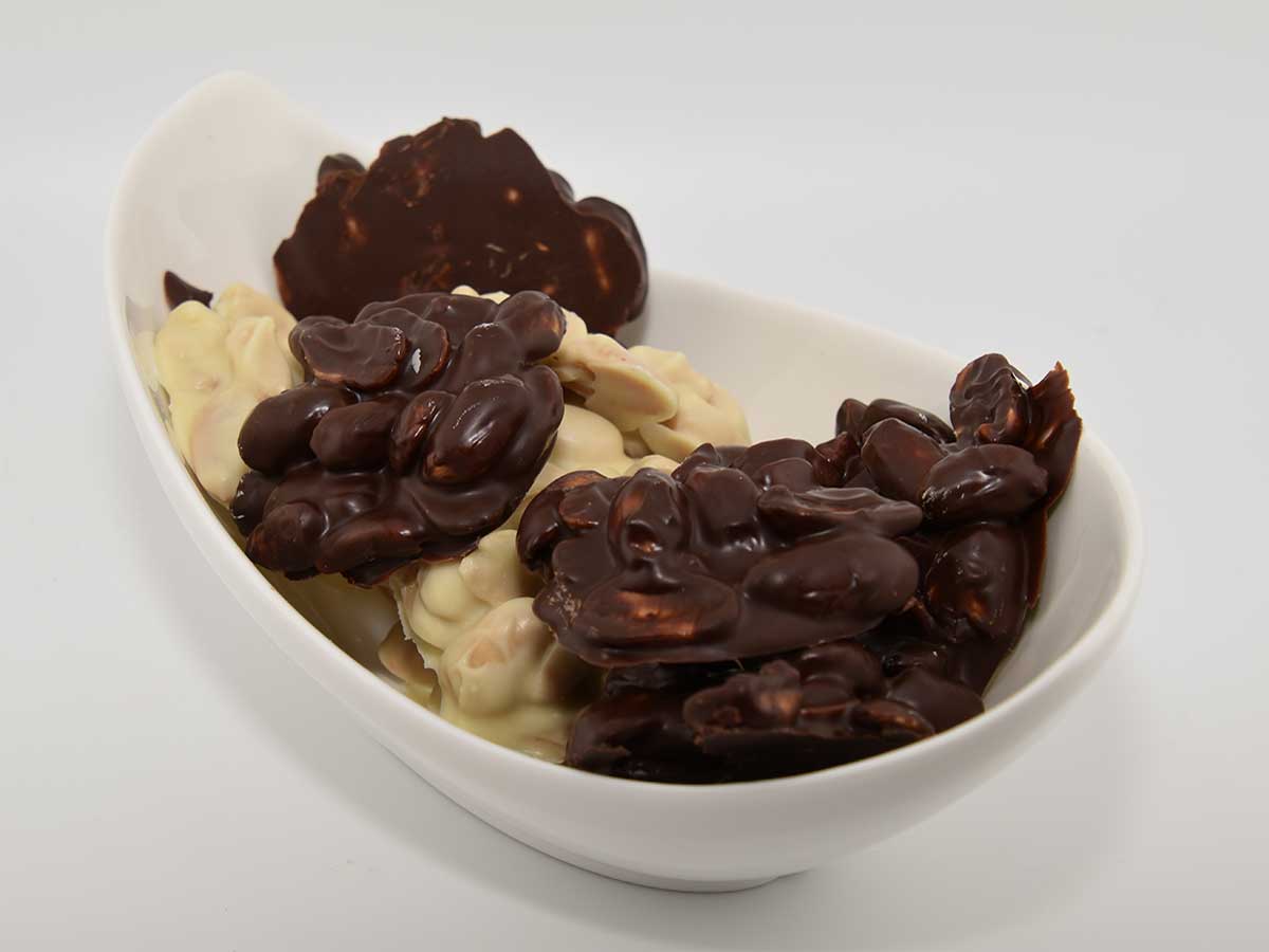 Een schaaltje met zelfgemaakte pindarotsjes, witte en pure chocolade.