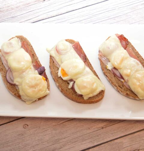 Een langwerpig bordje met 3 stukken Tiroler boerentoast.