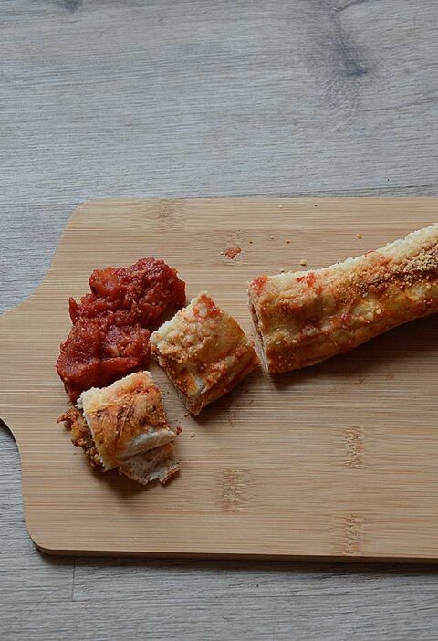 Een houten snijplank met daarop een wrap met gehakt uit de oven.