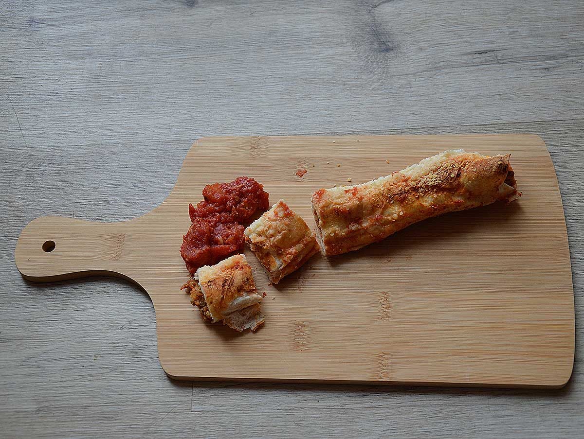 Een houten snijplank met daarop een wrap met gehakt uit de oven.