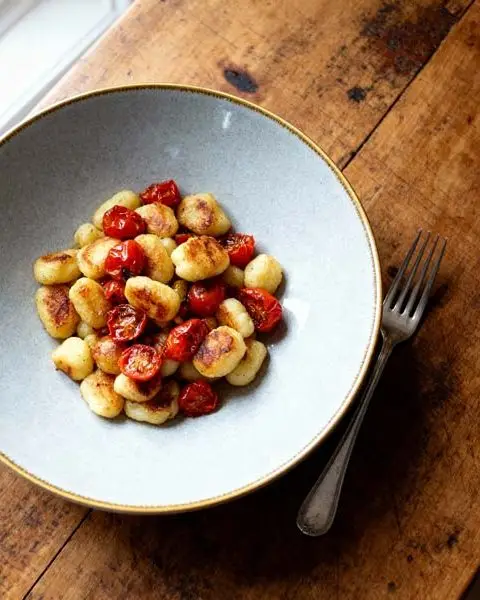 Gebakken gnocchie met tomaatjes, rucola en Parmezaanse kaas
