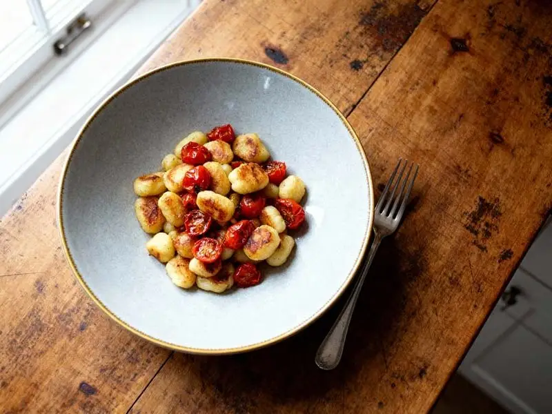 Gebakken gnocchie met tomaatjes, rucola en Parmezaanse kaas