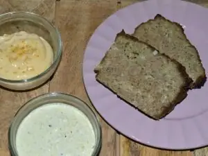 2 plakken gehaktbrood pesto met basilicumsaus op een paars bordje. met sauzen.