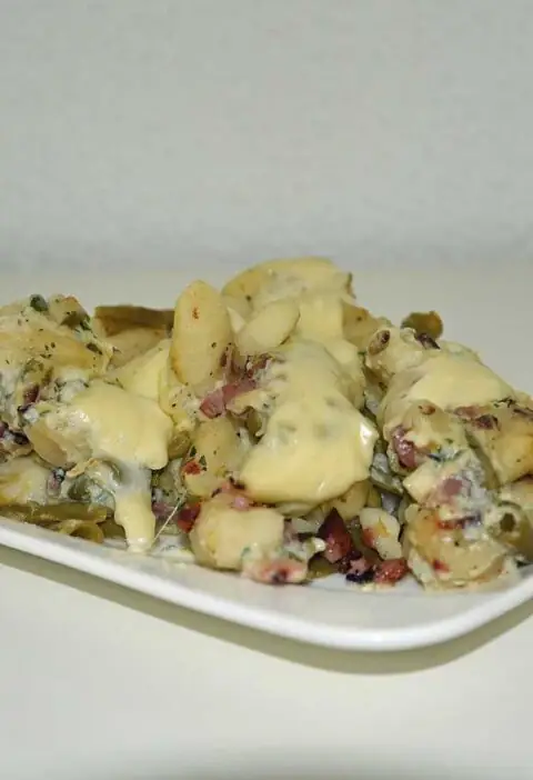 Gnocchi carbonara met bonen op een rechthoekig wit bordje.