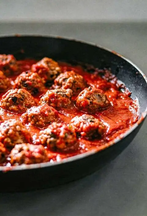 Een koekenpan vol met Italiaanse gehaktballetjes.
