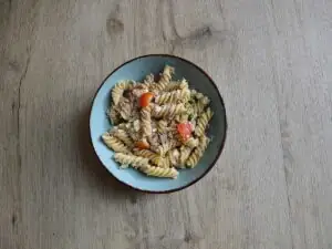 Koudepastasalade met tonijn in een lichtblauw schaaltje.