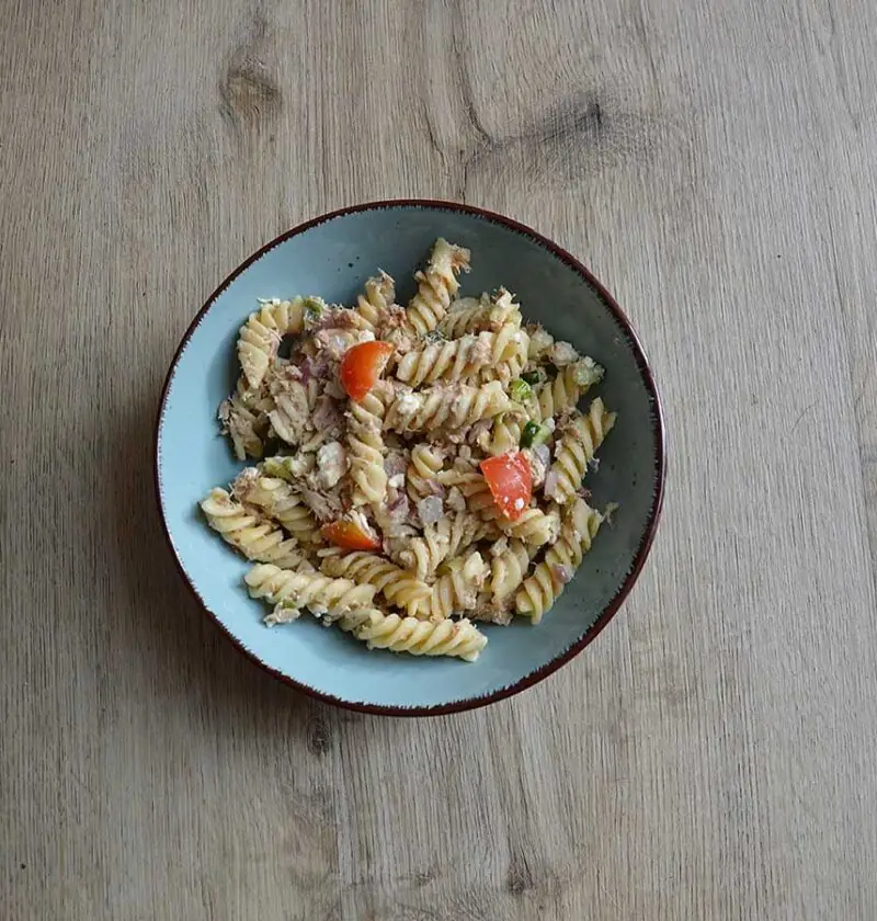 Koudepastasalade met tonijn in een lichtblauw schaaltje.