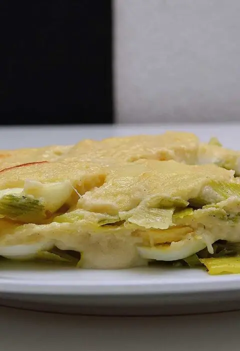 Lasagne met prei maar zonder vlees op een wit bord.