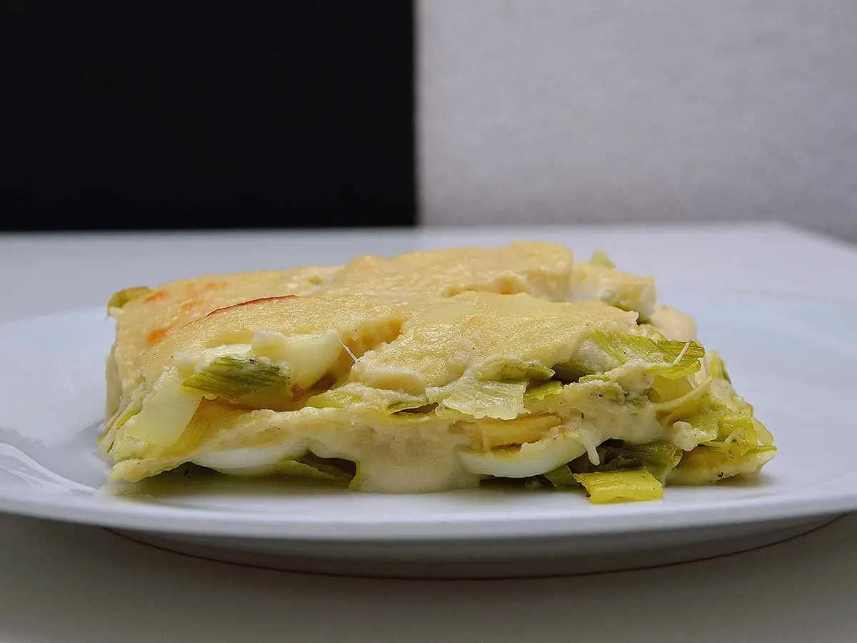 Lasagne met prei maar zonder vlees op een wit bord.