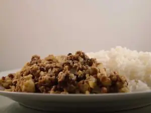 Linzen Bloemkool Curry met rijst, op een wit bord.