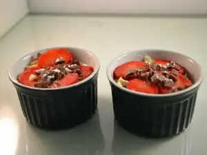 Mascarponekwark met aardbeien in twee kleine schaaltjes.