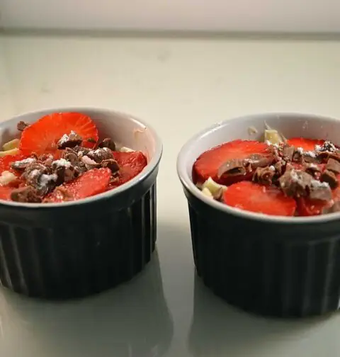 Mascarponekwark met aardbeien in twee kleine schaaltjes.