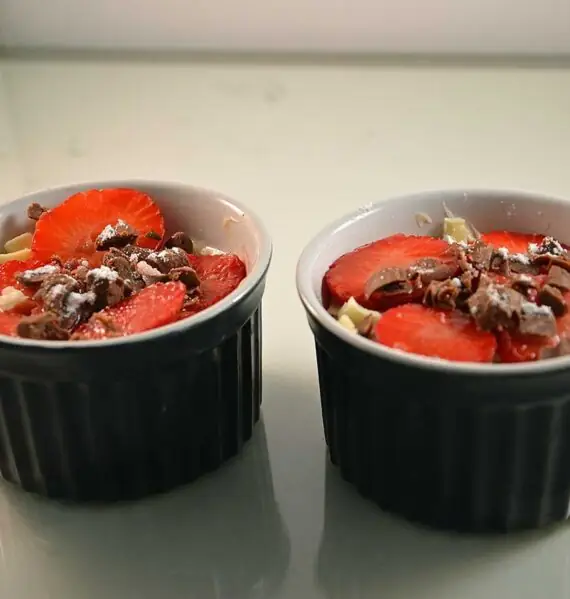 Mascarponekwark met aardbeien in twee kleine schaaltjes.