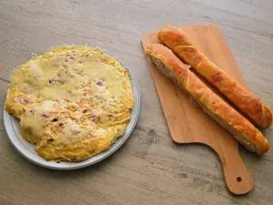 Omelet met worst en kaas op een bruine ondergrond.