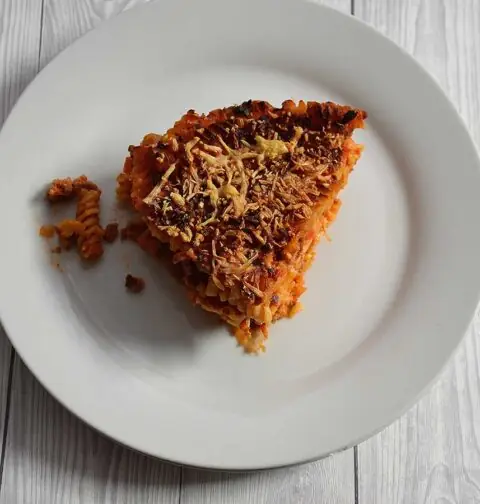 Een stuk pastataart Bolognese op een wit bord.