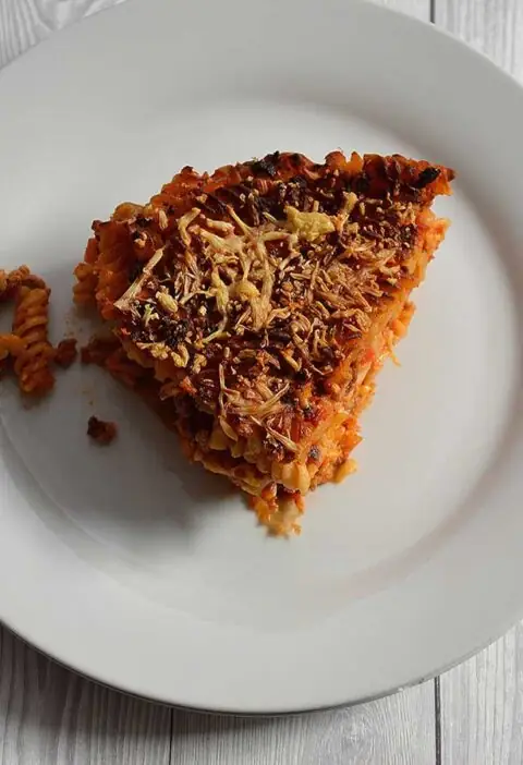 Een stuk pastataart Bolognese op een wit bord.