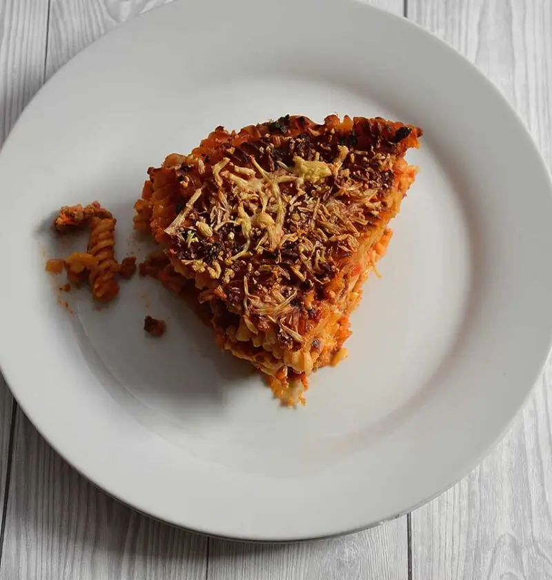 Een stuk pastataart Bolognese op een wit bord.