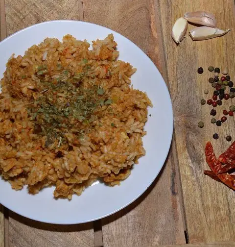 Shoarma nasi op een wit bord, met daarnaast wat smaakmakers.