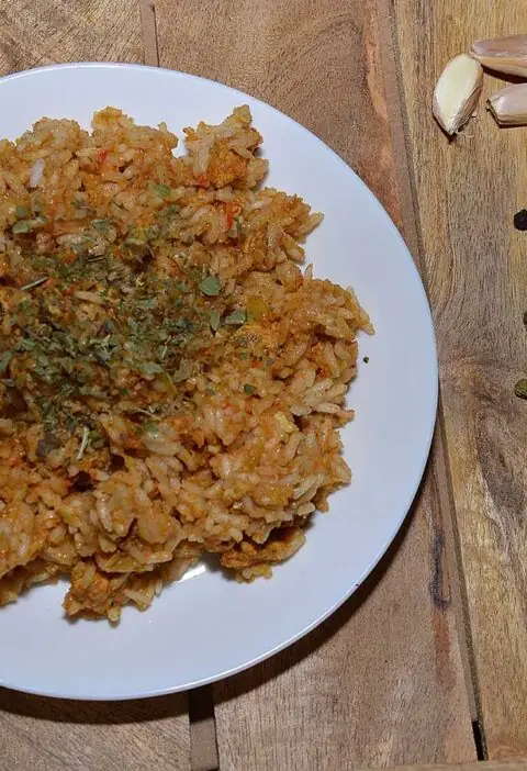 Shoarma nasi op een wit bord, met daarnaast wat smaakmakers.