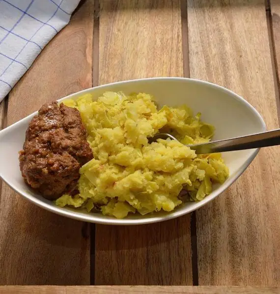 Een mooi schaaltje met stamppot prei en daarnaast een heerlijke gehaktbal.