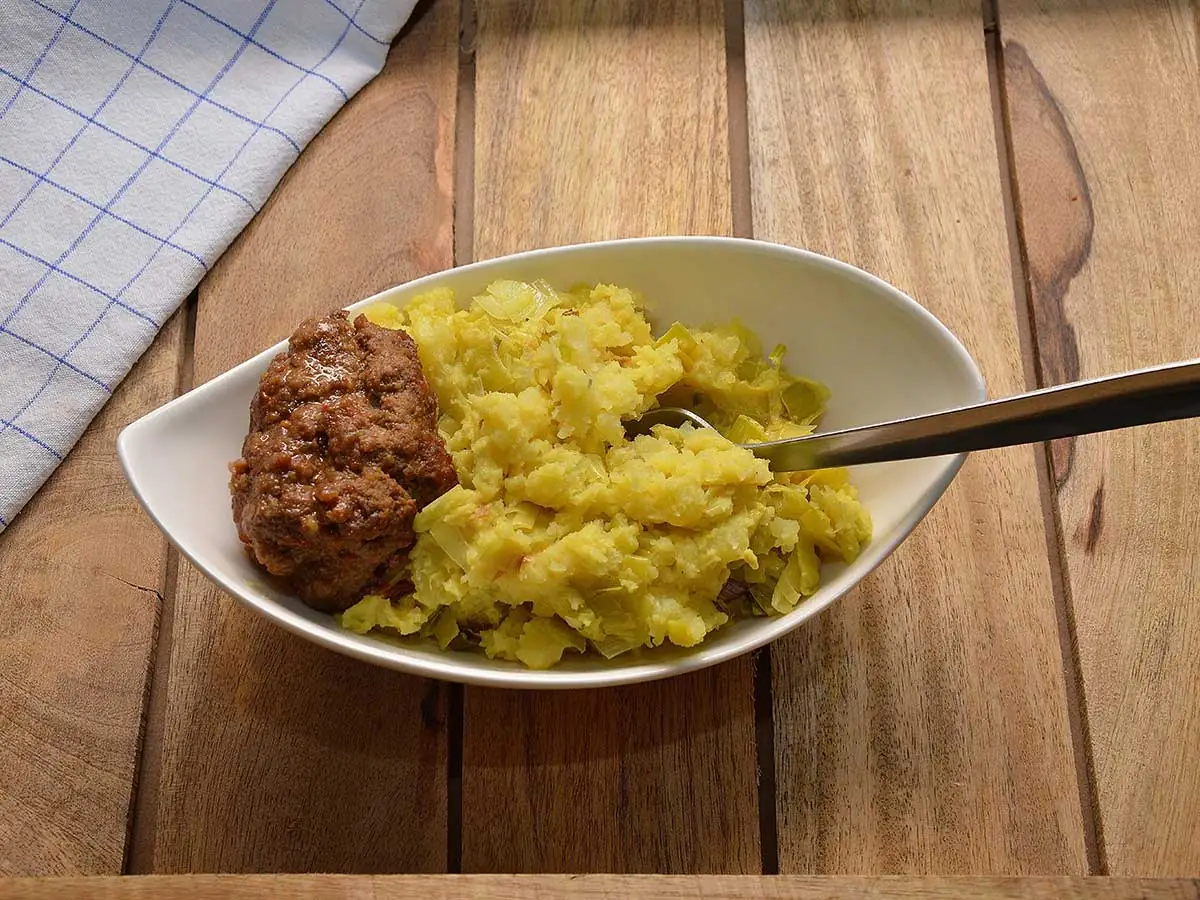Een mooi schaaltje met stamppot prei en daarnaast een heerlijke gehaktbal.